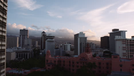 brillante cielo matutino con nubes tenues, icónico hotel real hawaiano en primer plano, antena