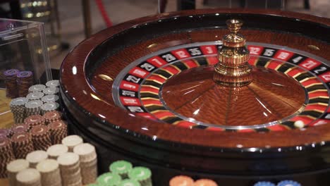 ruleta giratoria con bola y fichas alrededor de la mesa de juego en el casino, vista de cerca