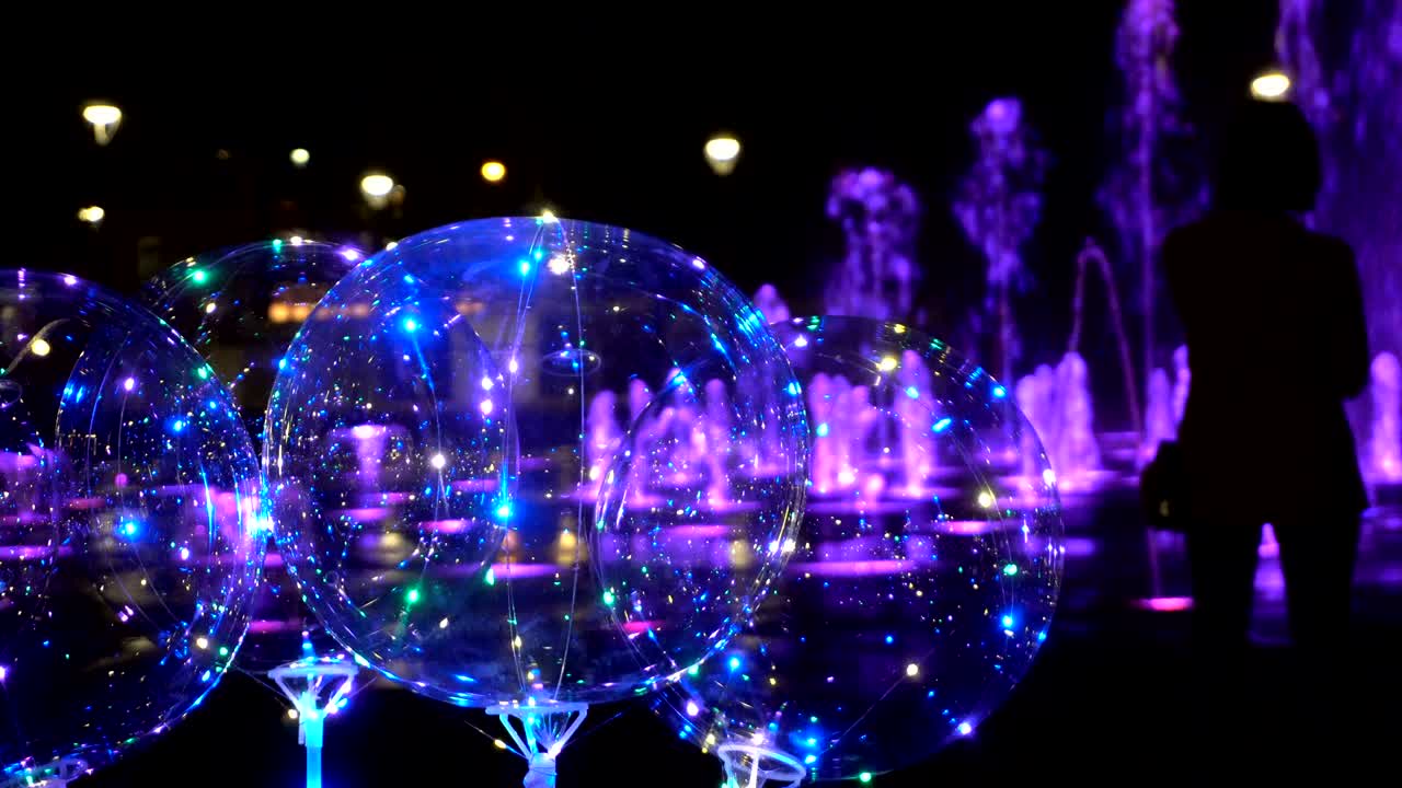 저녁 에 분수 의 배경 에 있는 다채로운 투명 한 공 들