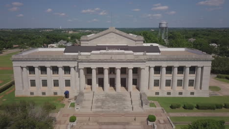 aerial drone shot of white house with tree in the side