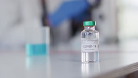 botella de vial con texto covid-19 en la mesa en el laboratorio