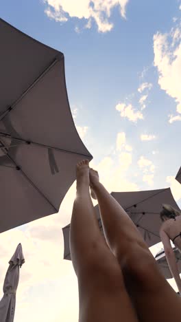 legs up in the sun, relaxing under umbrellas