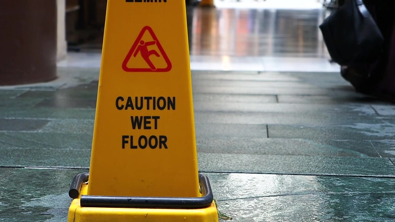 Yellow Caution Wet Floor Sign on a Slippery Tiled Surface
