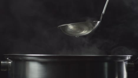 close up of a soup cooking process. sukiyaki or shabu in a pot, cooking in slow motion on the black background