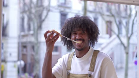 happy man enjoying a slice of pizza with a cheese pull