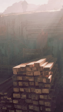 a stack of lumber sits in front of a weathered building in the morning mist.