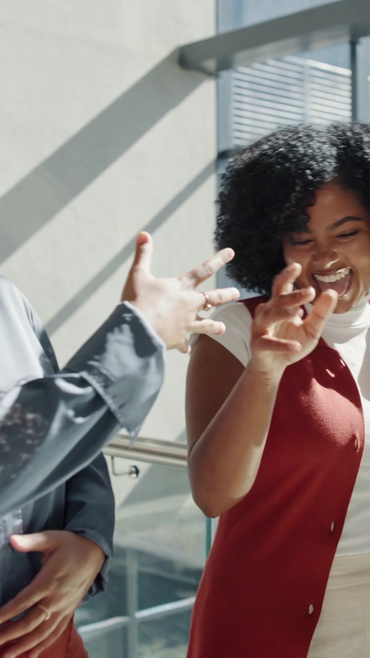 Two Professional Women Celebrating Success with a Fist Bump in Office
