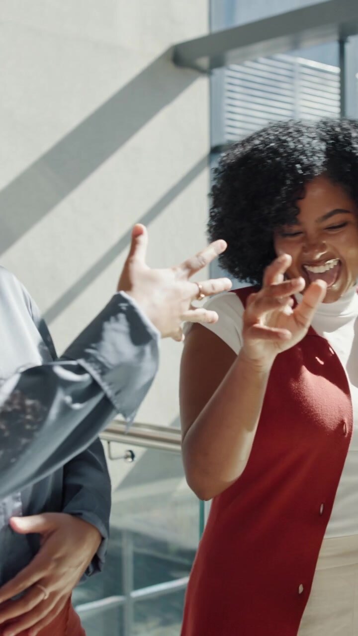 Two Professional Women Celebrating Success with a Fist Bump in Office