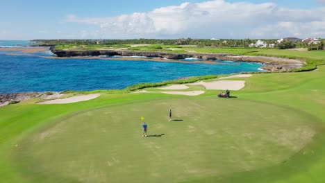 spieler auf dem green of corales golfplatz neben dem azurblauen karibischen meer