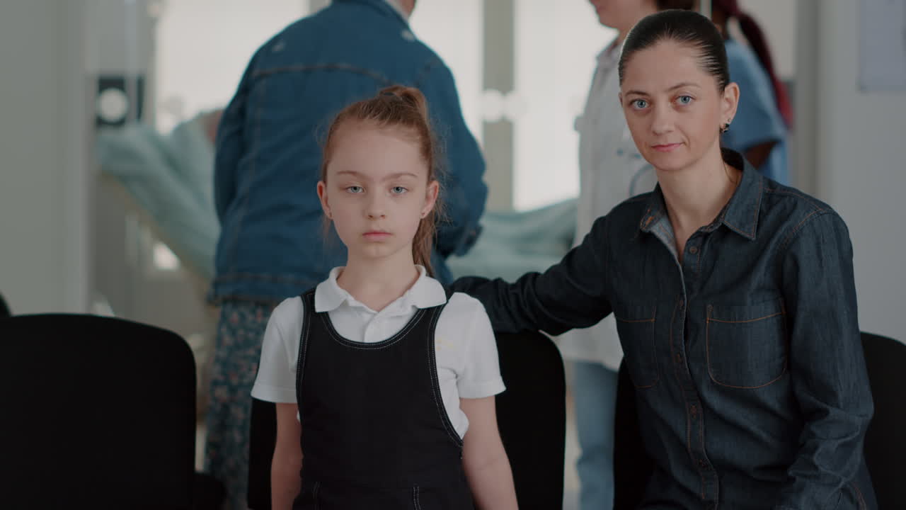 Portrait of mother and child sitting in waiting room at clinic