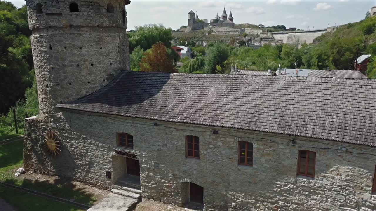 Aerial view of old Castle further and tilt down on Ruthenian Tower Building towards ground level at Kamianets Podilskyi,Ukraine on a sunny day.