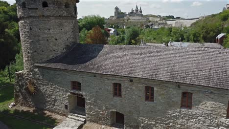 aerial view of old castle further and tilt down on ruthenian tower building towards ground level at kamianets podilskyi,ukraine on a sunny day.
