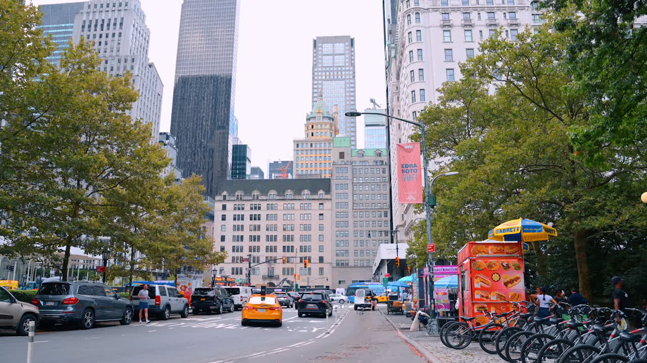 New York, USA, 4 August 2025: Busy street with yellow taxis and food stands in New York City. Lively street in New York City with yellow taxis, food stands, and modern skyscrapers in the background
