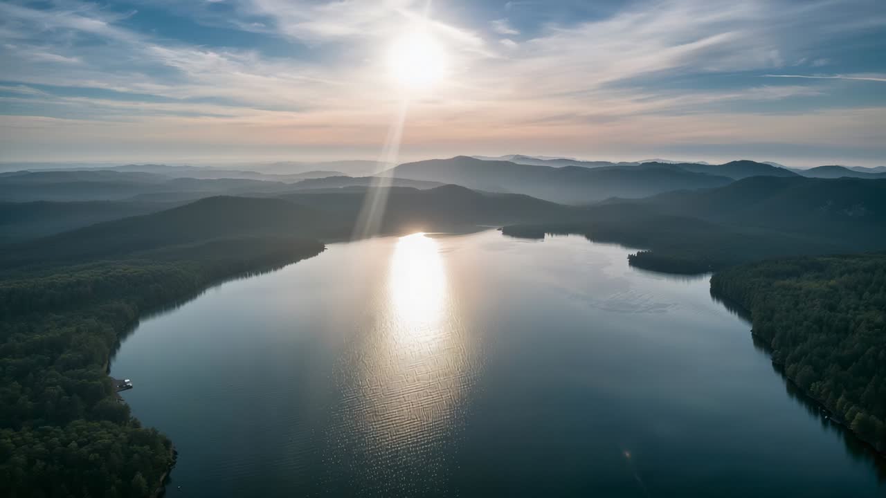 Viser fjellvann som reflekterer soloppgangen mens en drone panorerer, og avslører brygge og rygger for soloppgang