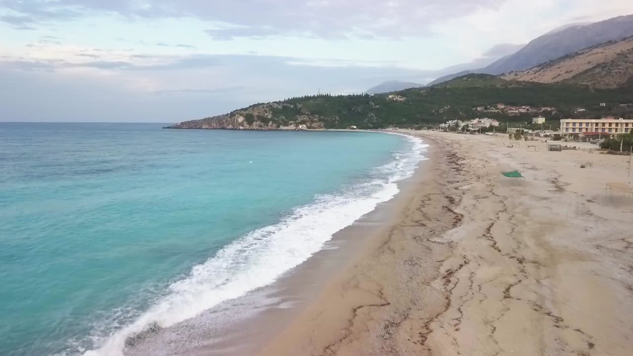 Beautiful sunrise on Livadhi Beach while camping on the beach of the Albanian Riviera with waves into the coastline