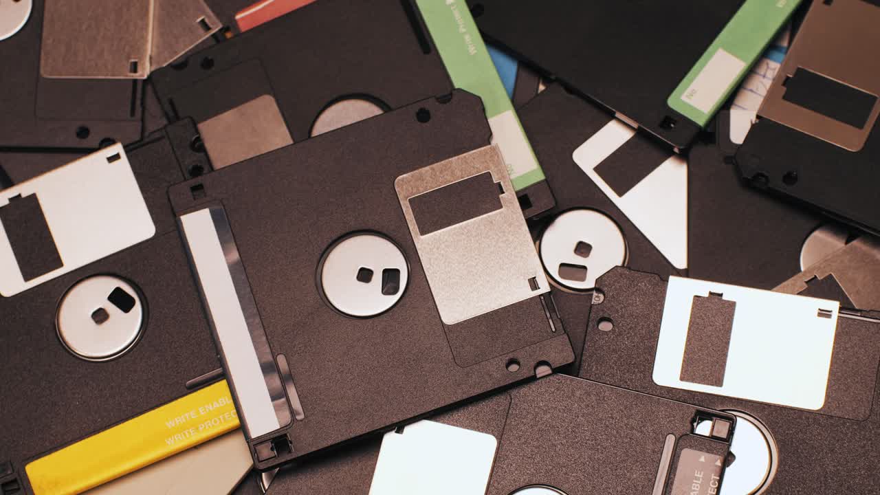 Hand holding a pile of floppy disks