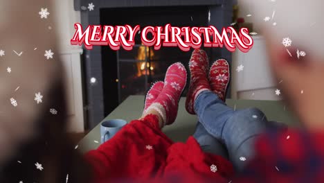 Animation-of-christmas-greetings-text-with-couple-by-fireplace-at-christmas