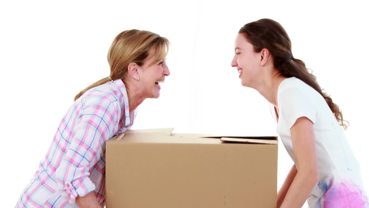 Mother and daughter carrying box together
