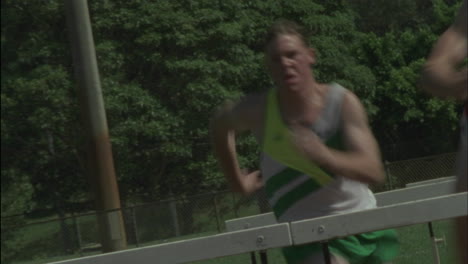 A-group-of-men-jump-hurdles-on-a-running-track