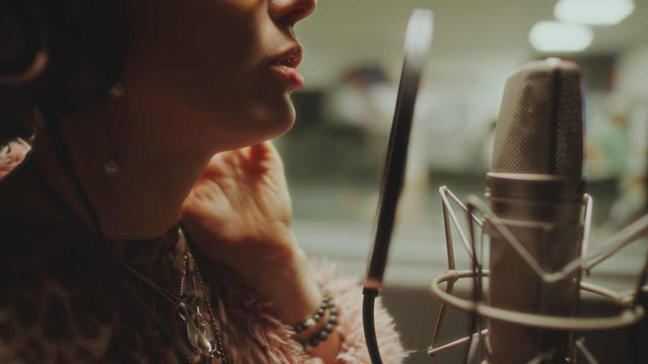 Close-Up of Female Musician Singing into Microphone in Recording Booth