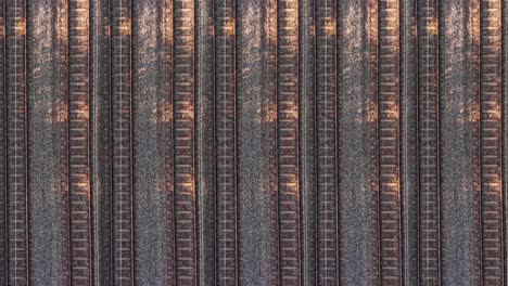 drone above pattern of rail trains passing by multiply rails, aerial view above tracks and trains