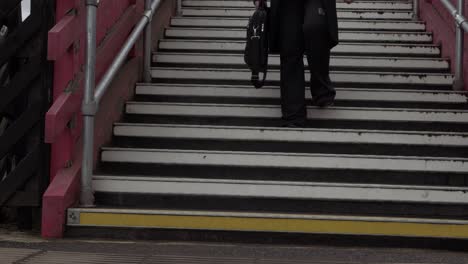 business woman descends steps in urban train station