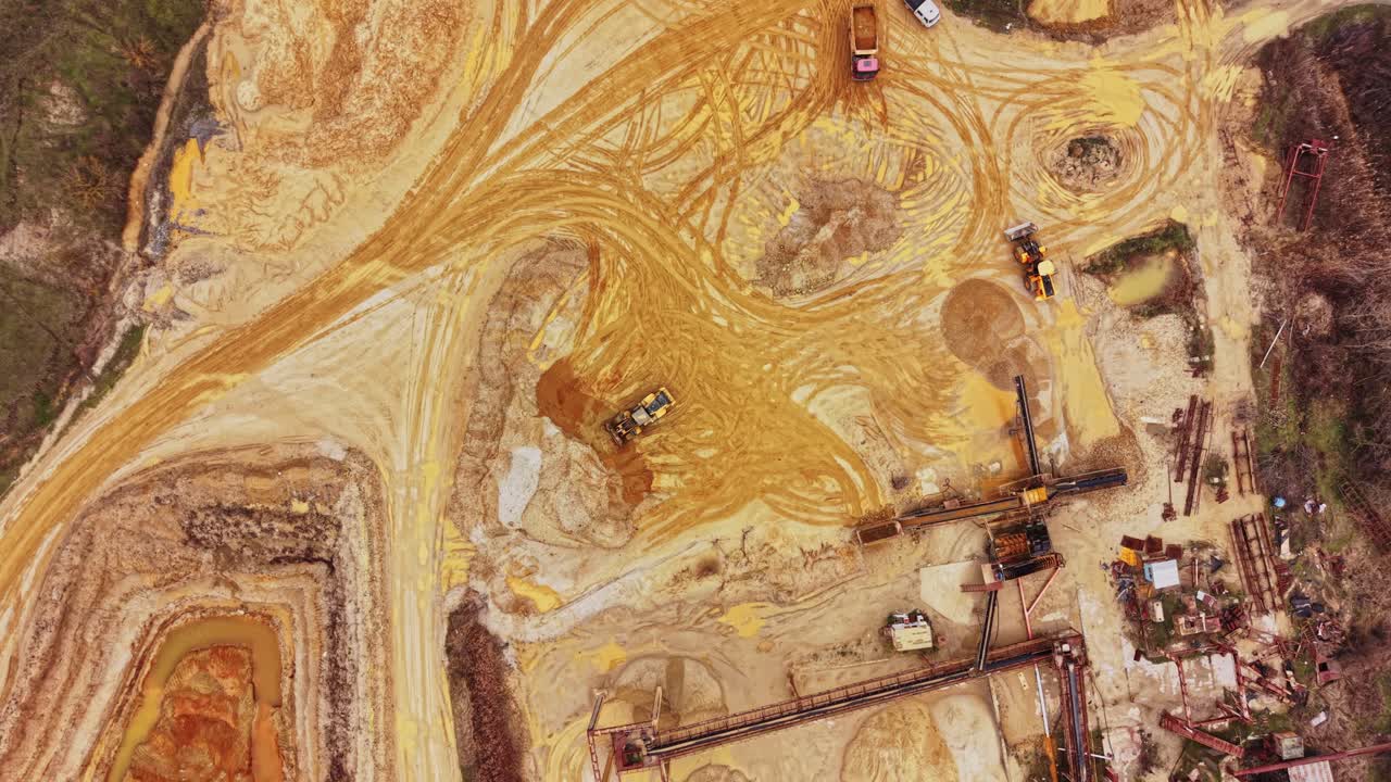 Sandgrube mit Maschinen und abgebauten Flächen bei Tageslicht