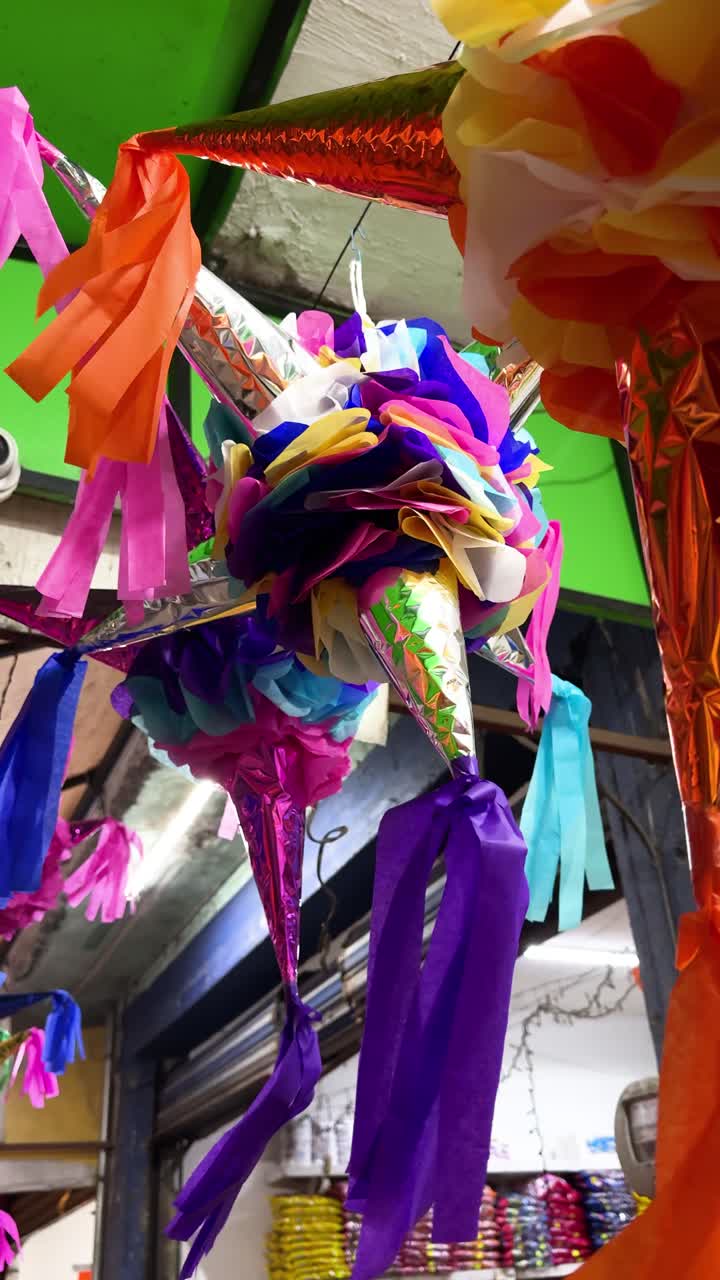 Colorful Christmas piñatas with vibrant paper decorations hanging outdoors during festive celebrations