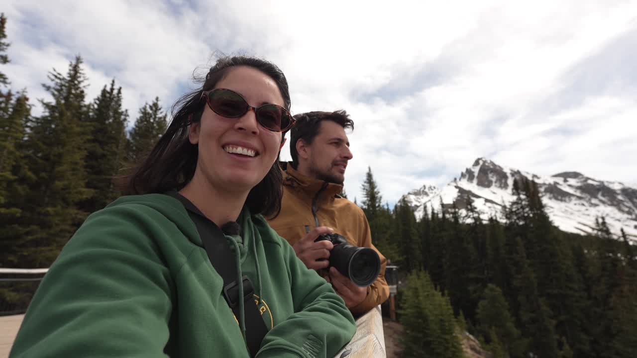 Coppia che fa vlogging e fotografa le montagne durante un'avventura di viaggio all'aperto