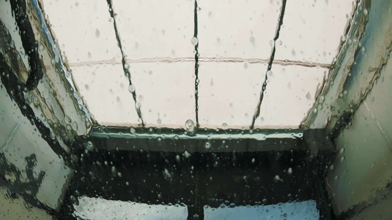 세차장에서 차량 앞유리에 물이 뚝뚝 떨어집니다.