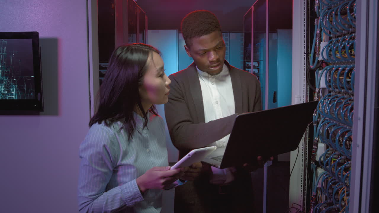Multi-Ethnic Technicians Checking Equipment in Data Center