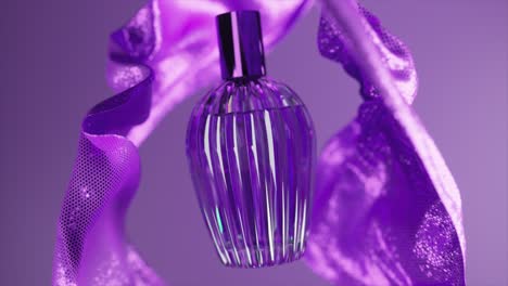 botella de perfume púrpura con tela drapeada