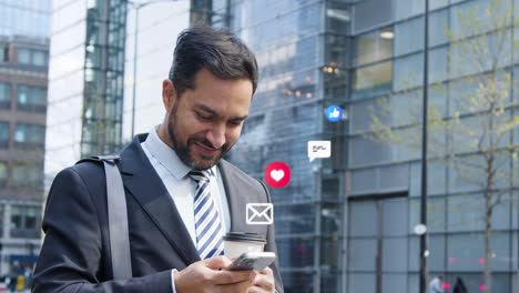 hombre de negocios sonriente de pie fuera de las oficinas de la ciudad mirando el teléfono móvil con emojis de gráficos de movimiento que muestran múltiples mensajes y notificaciones de redes sociales