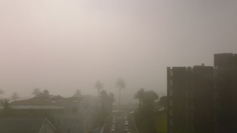 Mist-in-city-in-tropical-location.-Backwards-reveal-of-street-and-residential-houses.-Cape-Town,-South-Africa