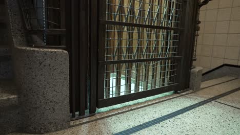 medium shot of old vintage elevator arriving empty at the floor of a building