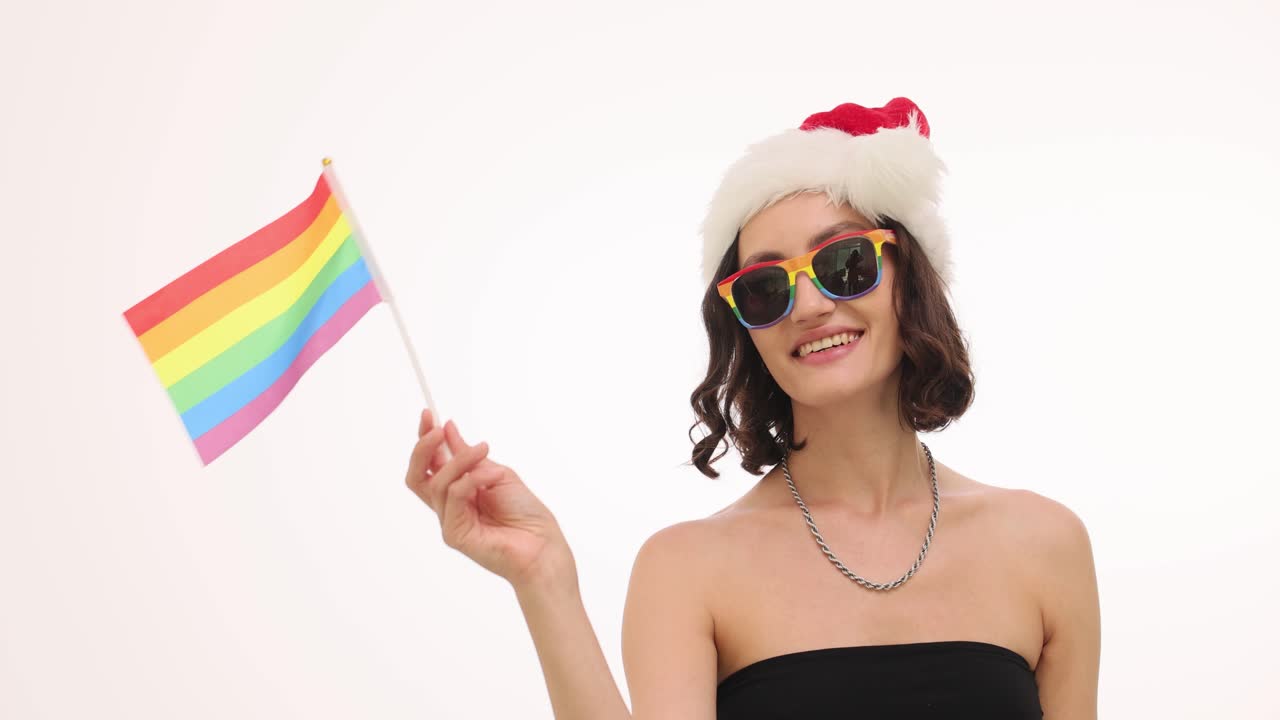 Woman wearing Santa hat and holding a rainbow flag