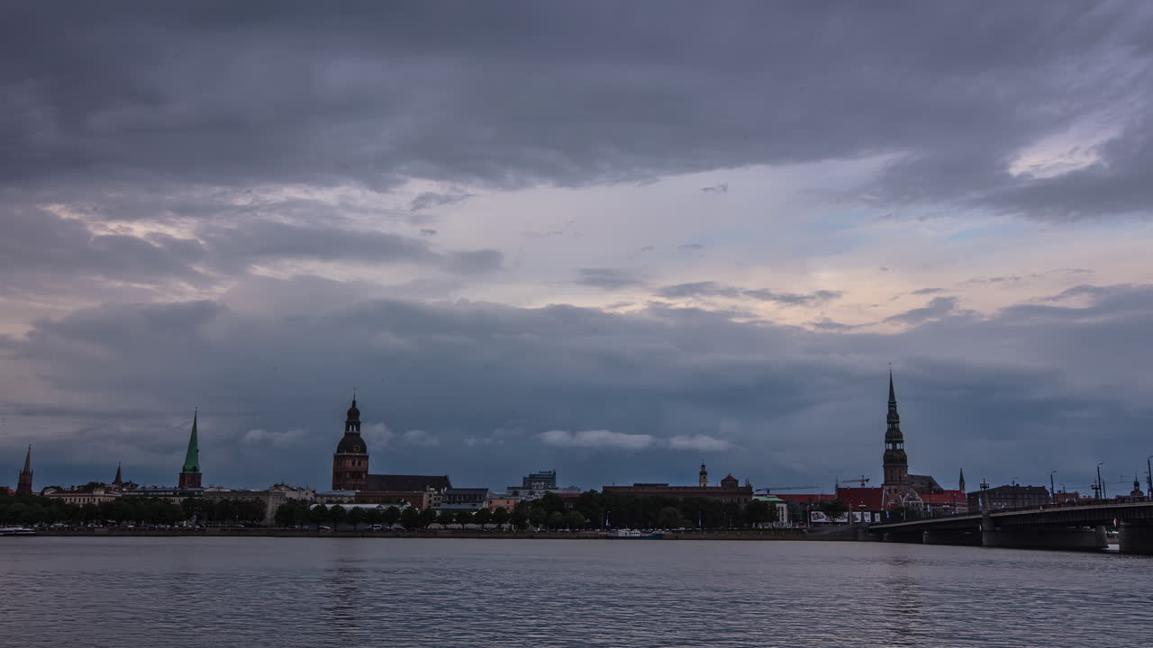 nubes de tormenta ruedan sobre el paisaje urbano de riga, vista de lapso de tiempo de fusión
