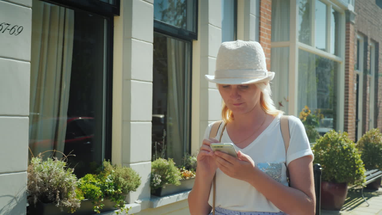 женщина со смартфоном во время прогулки по делфту