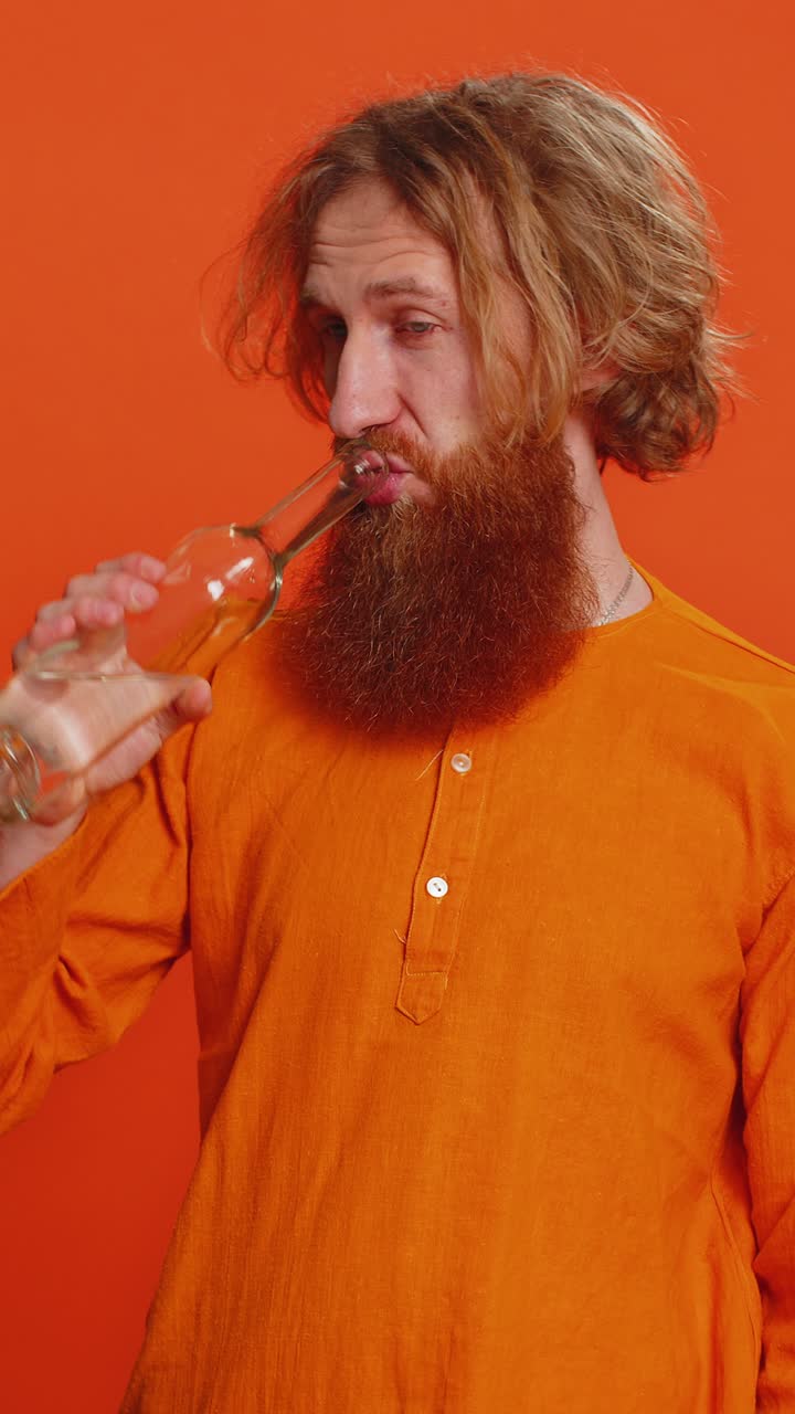 Drunk caucasian man after party drinks vodka beverage from bottle celebrating victory win addiction