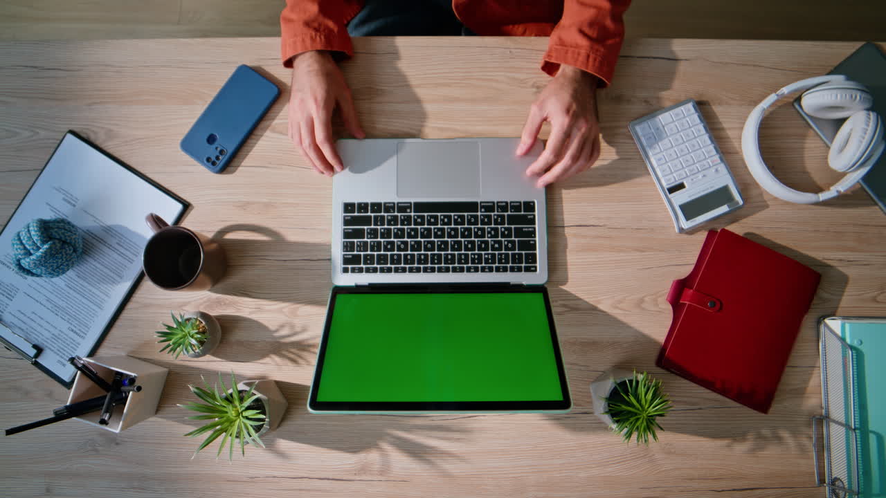 Employee using touchpad green screen laptop working online at apartment top view