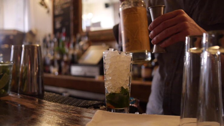 Mixologo che prepara un Queen Park Swizzle, mescolando un Mojito.