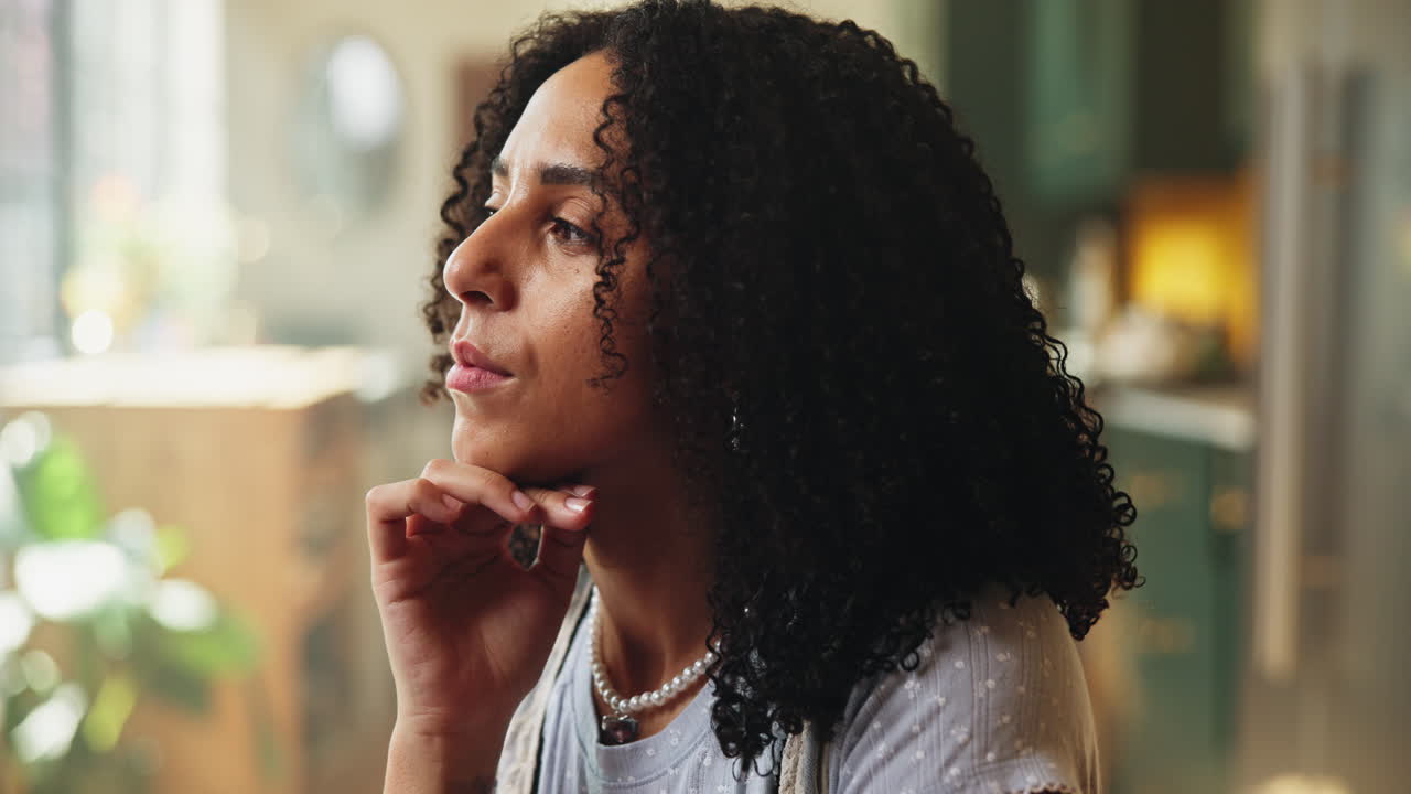 Young Woman with Curly Hair Looking Thoughtful and Smiling