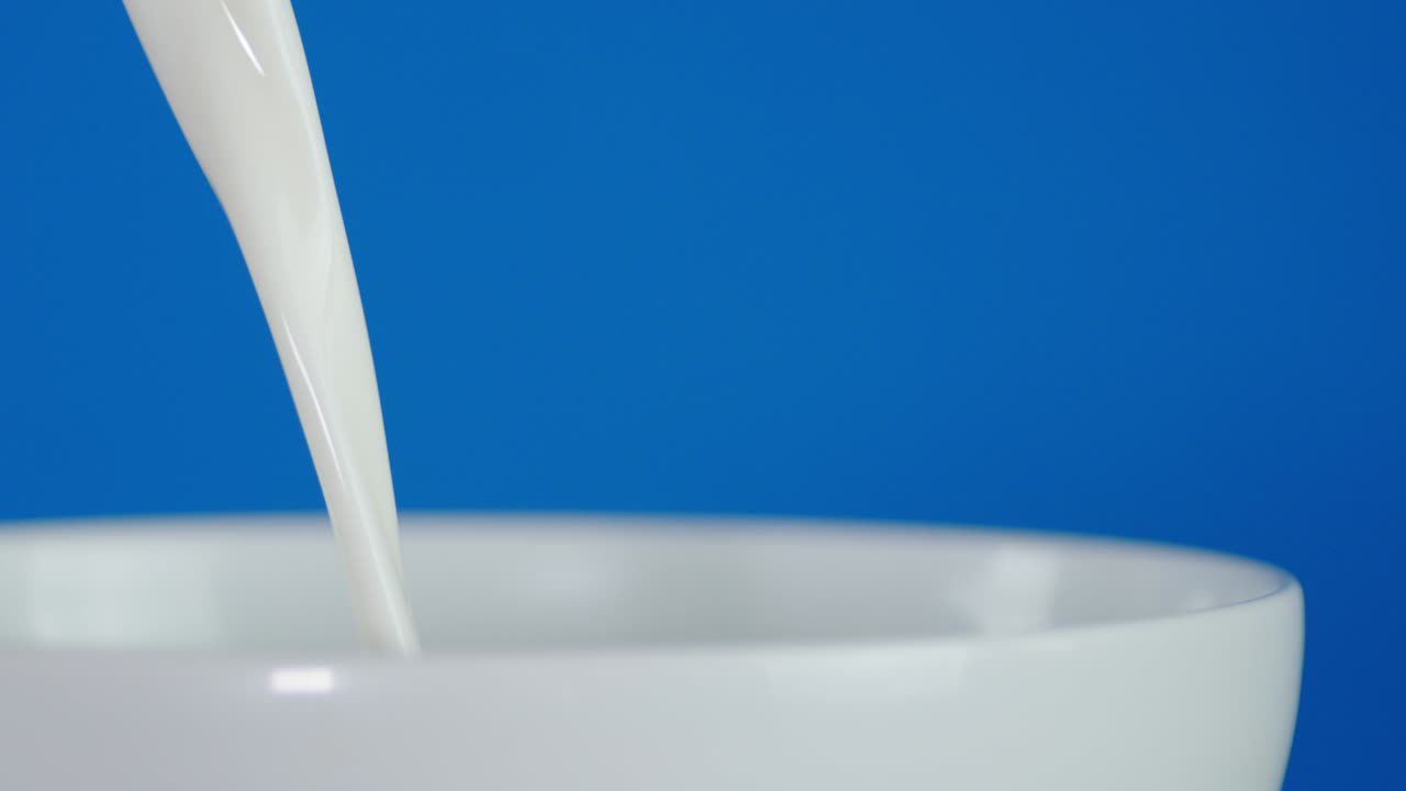 se vierte leche fresca de un vaso.