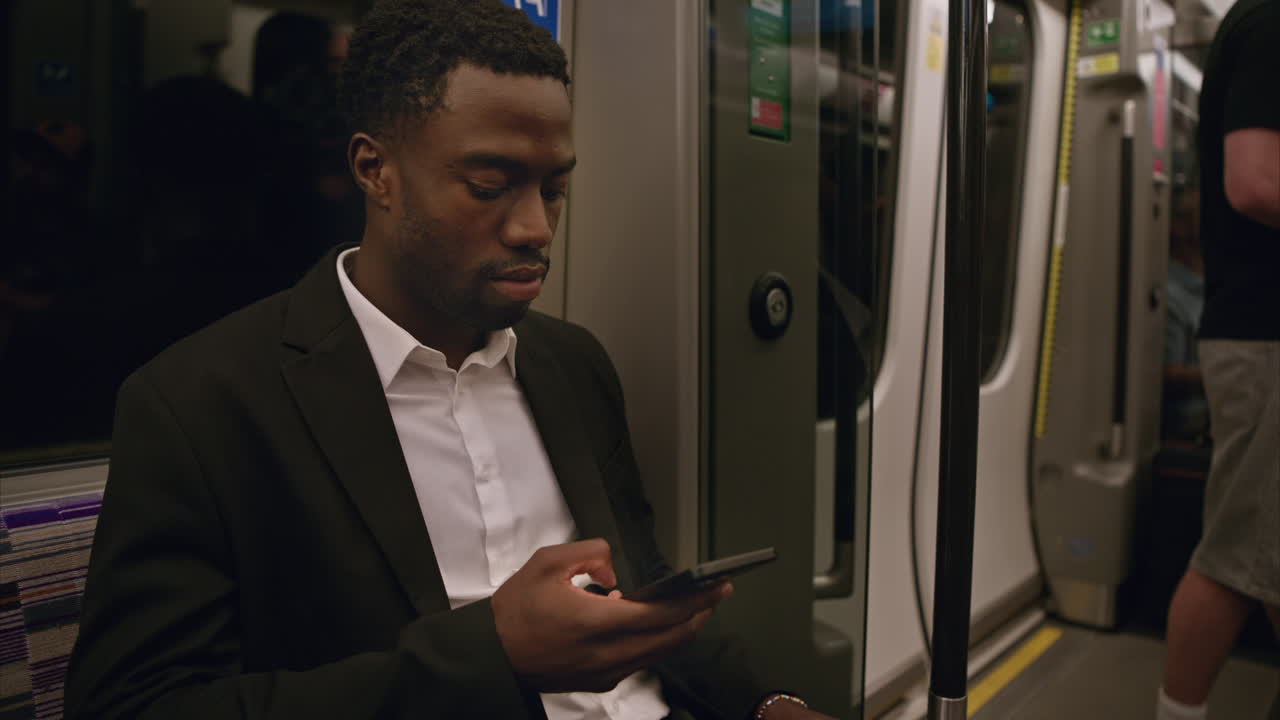 런던 지하철 열차에 앉아 실시간으로 찍은 드폰을 사용하는 청년 사업가.