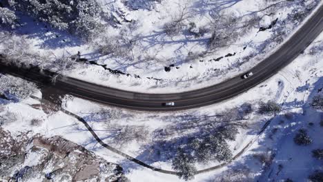 cars driving down winter road in boulder canyon, colorado - aerial drone footatge - daytime