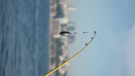 fishing rod with sinker and line by water