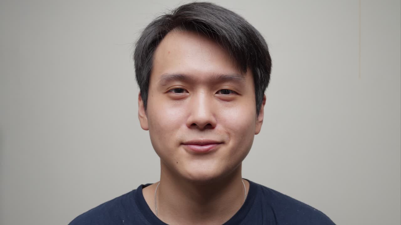 중국인 남자가 선글라스를 벗고 미소 짓기 시작하는 근접 사진