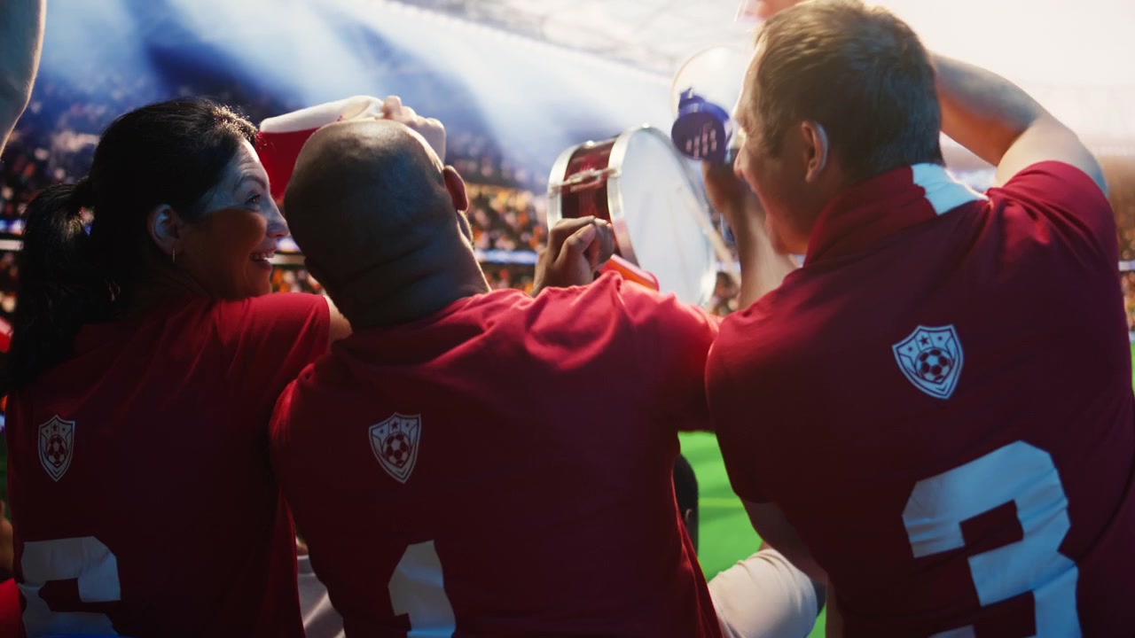 Primo piano di un tifoso di calcio che fa rumore con vuvuzela e trombe ad aria durante la partita.