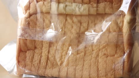 Close-up-of-fresh-bread-in-a-plastic-packet-on-table-,