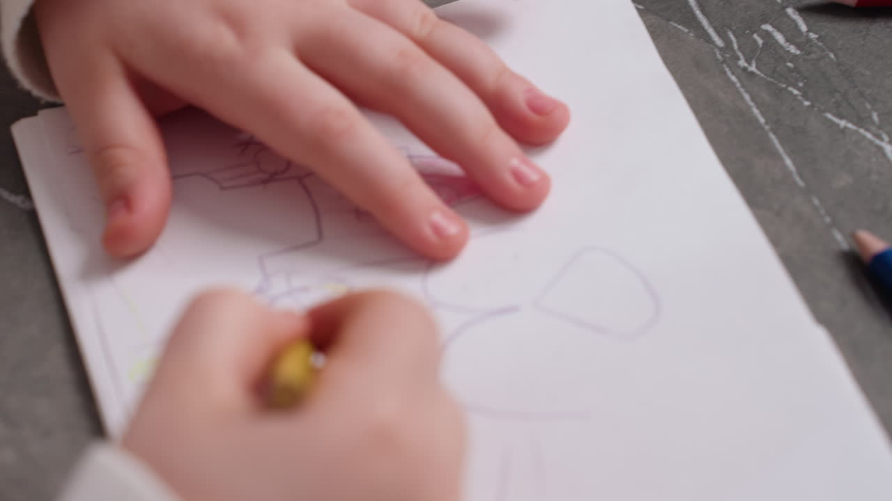 Close up of student hand reaching for colorful pencils scattered on gray table surface, imagination, childhood play and artistic exploration during drawing activity indoors